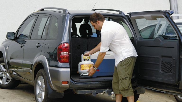 man-putting-bbq-cylinder-in-car