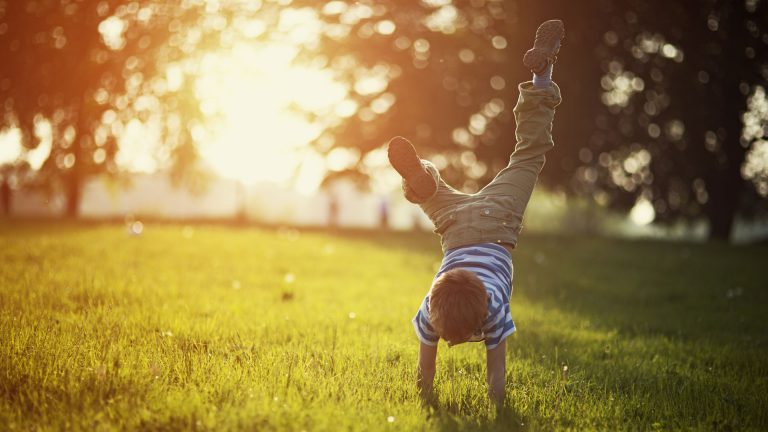 child cartwheel grass sun tall
